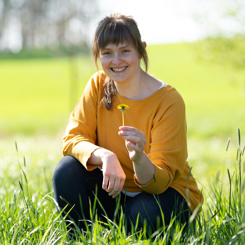 Marie-Therese Stedry © Waldspatz-Medien; Resi hält eine Löwenzahnblüte in Ihrer Hand als Symbol Ihrer Haltung zum Thema