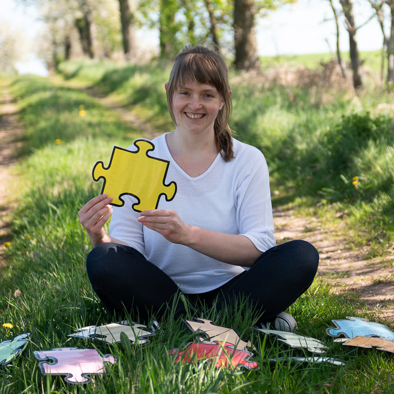 Marie-Therese Stedry © Waldspatz-Medien; Resi hält ein Puzzlestück als Teil Ihres Konzeptes